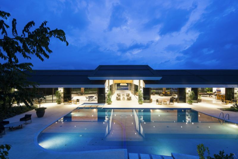 Hotel building with illuminated pool at dusk