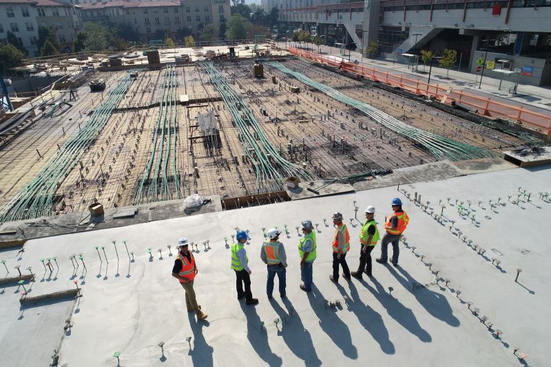 Aerial view of a large construction site with engineers in high-visibility jackets